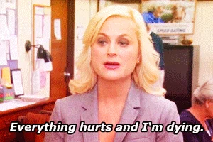 Woman in office smiling and saying 'Everything hurts and I'm dying' - capturing how period pain feels while trying to work